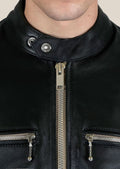 Slim fit black leather jacket with silver zippers on the chest, pockets, and sleeves, worn by a male model.